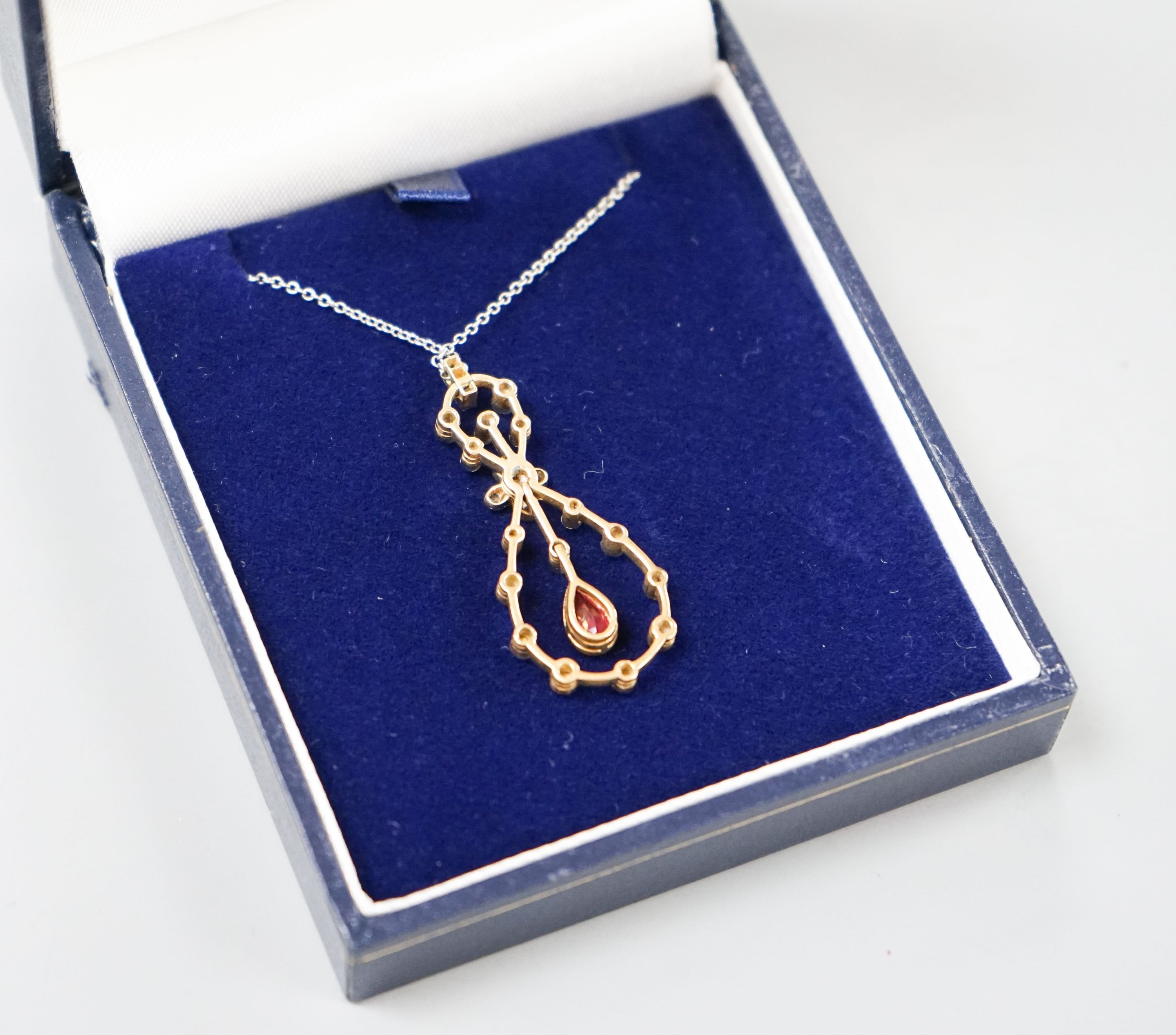 A modern 1920's style white metal, ruby and diamond set openwork oval drop pendant necklace, pendant 37mm, gross weight 6.1 grams.